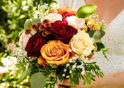 La mariée porte un magnifique bouquet aux couleurs vives, une explosion florale éclatante qui ajoute une touche de splendeur à son allure.