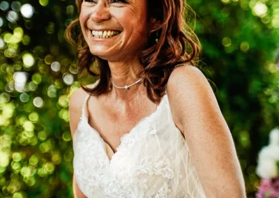 Capture joyeuse : Le sourire éclatant d'une femme rayonne de bonheur lors de son mariage, magnifié par un fond lumineux et magique.